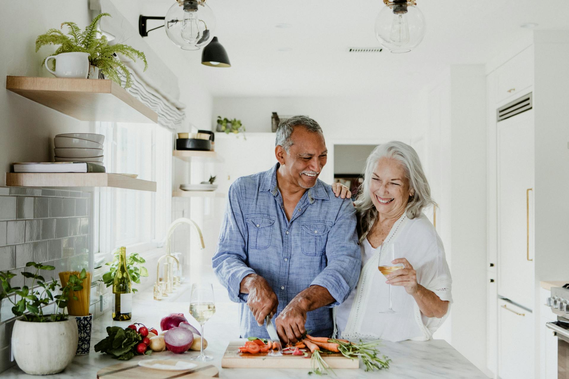 couple laughing while cooking together in the kitchen