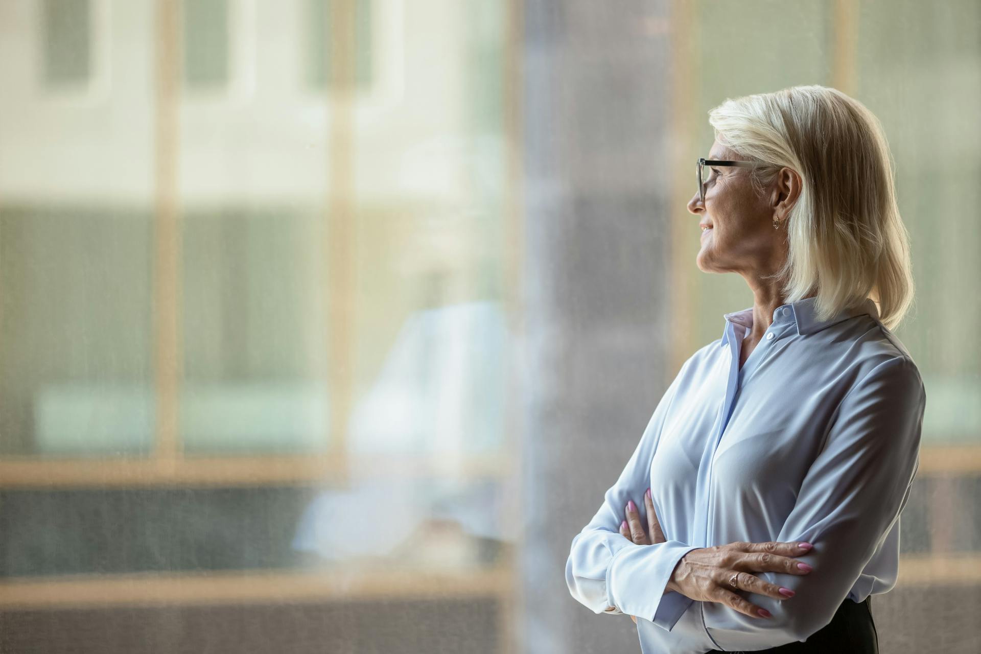 woman with her arms crossed staring out the window