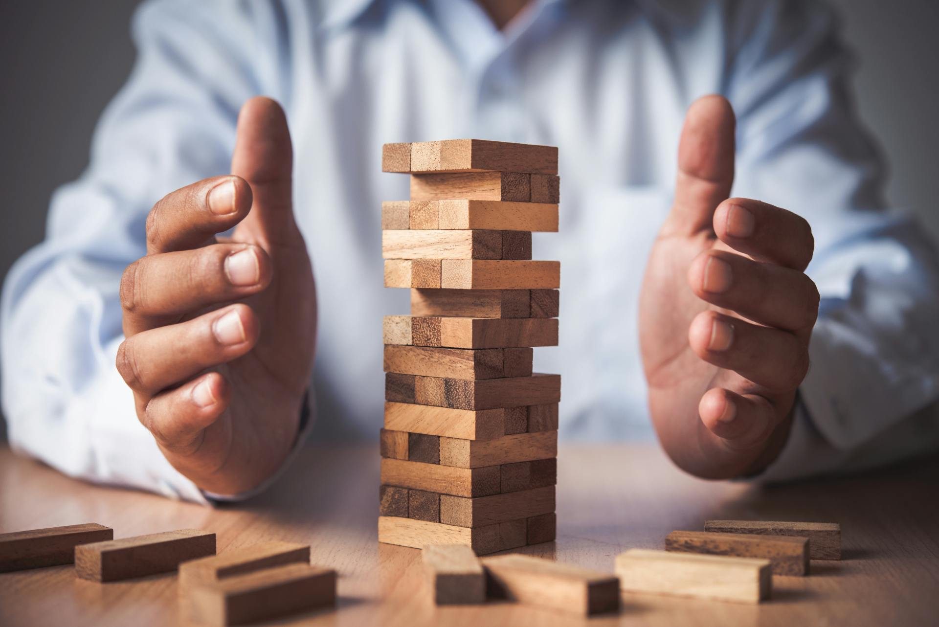 man with his hands around stacked blocks