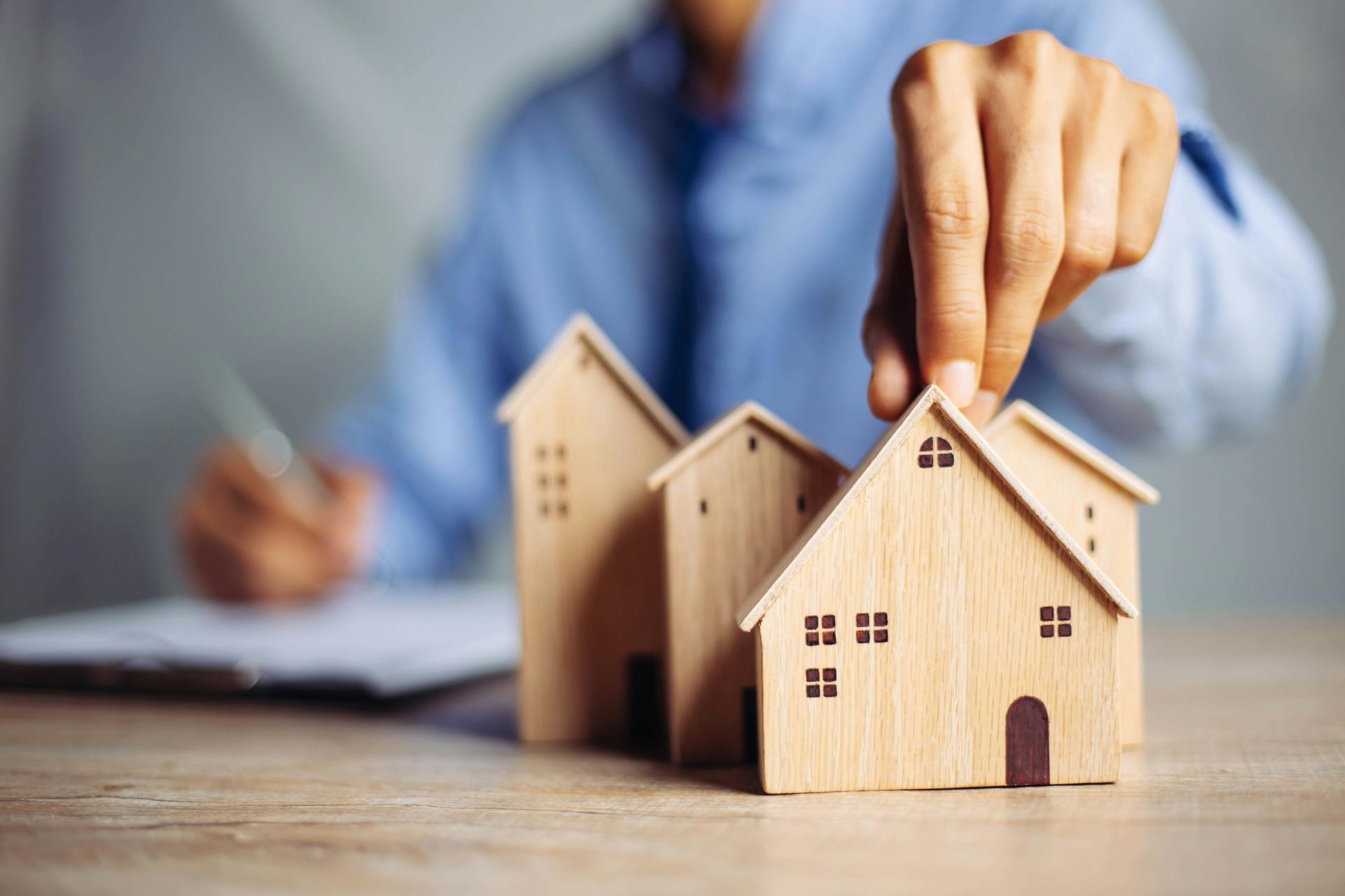 man holding up houses