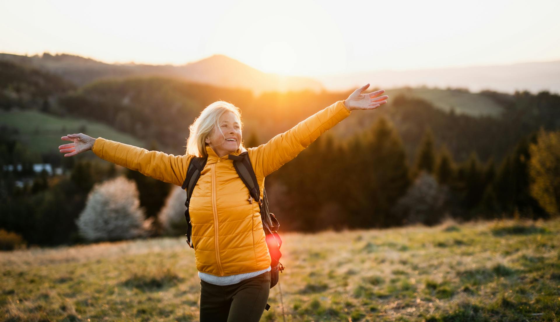 woman hiking smiling with her arms out