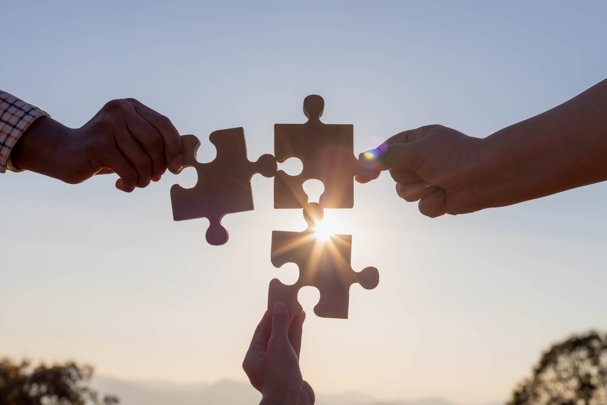 Hands,Holding,Piece,Of,Blank,Jigsaw,Puzzle,At,Sunset,Background