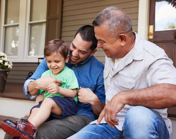 family sitting on the porch laughing