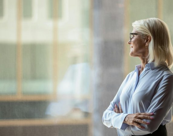 woman with her arms crossed staring out the window